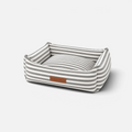 Cama para perros BIMBAS BRAND con estampado de rayas grises y blancas, desenfundable y con etiqueta de cuero frontal.