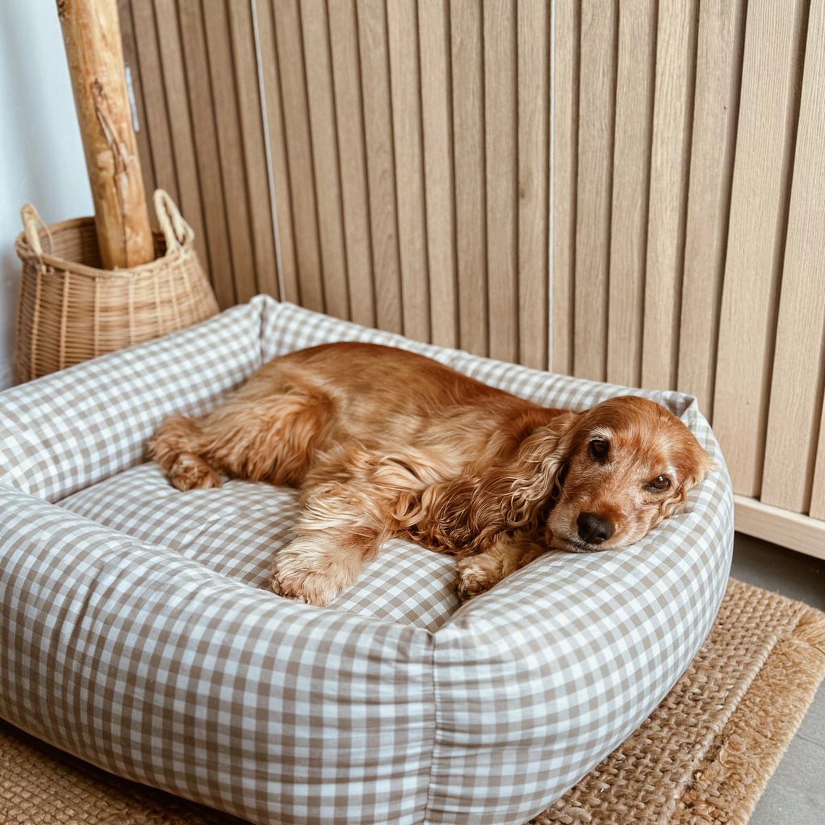 Cama para perros BIMBAS BRAND con estampado vichy beige, desenfundable, impermeable y cómoda con perro descansando