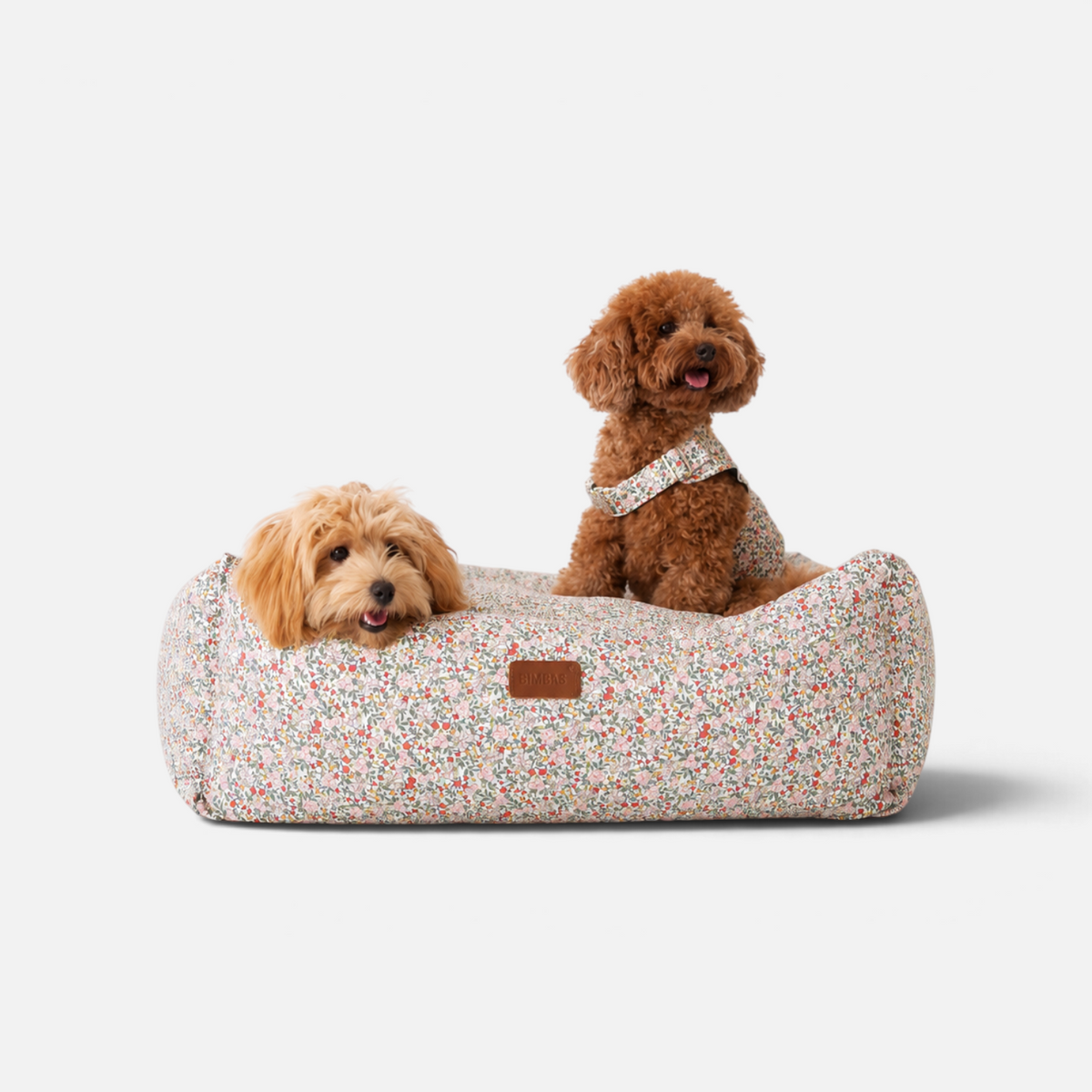 Cama para perros BIMBAS BRAND con estampado de flores, desenfundable, impermeable y con dos perros pequeños encima.