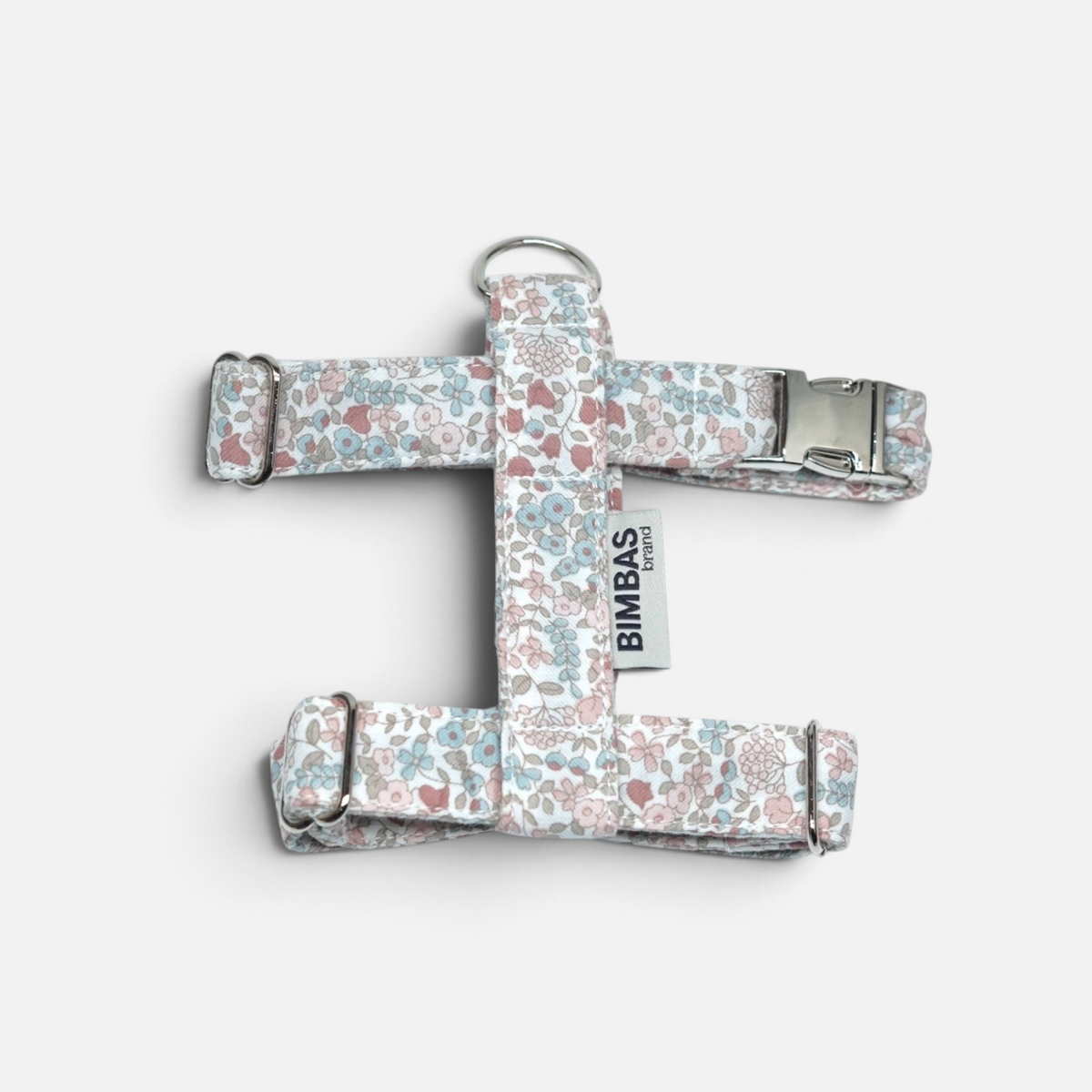 Arnés ajustable BIMBAS BRAND en algodón con estampado floral rosa y azul, cierre metálico y hebillas resistentes.